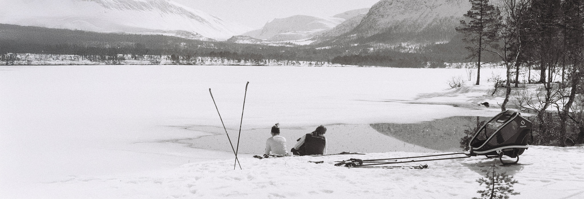 Mann og kvinne ved innsjø om vinteren, med Janus ullundertøy på