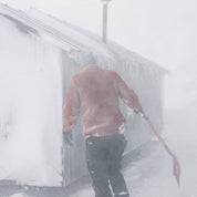 Mann på snøfjell med Janus Wool Finse genser i farge rød