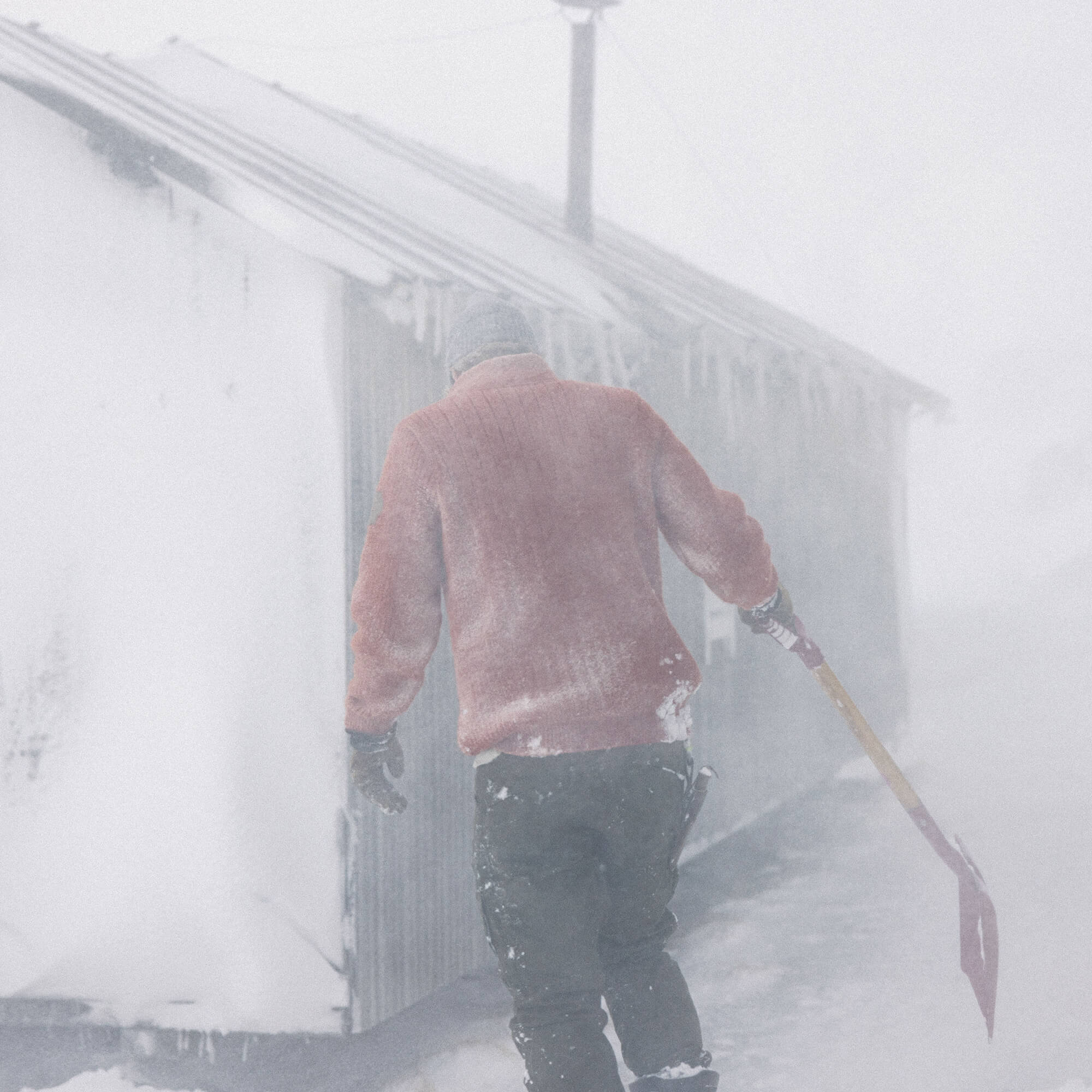 Mann på snøfjell med Janus Wool Finse genser i farge rød