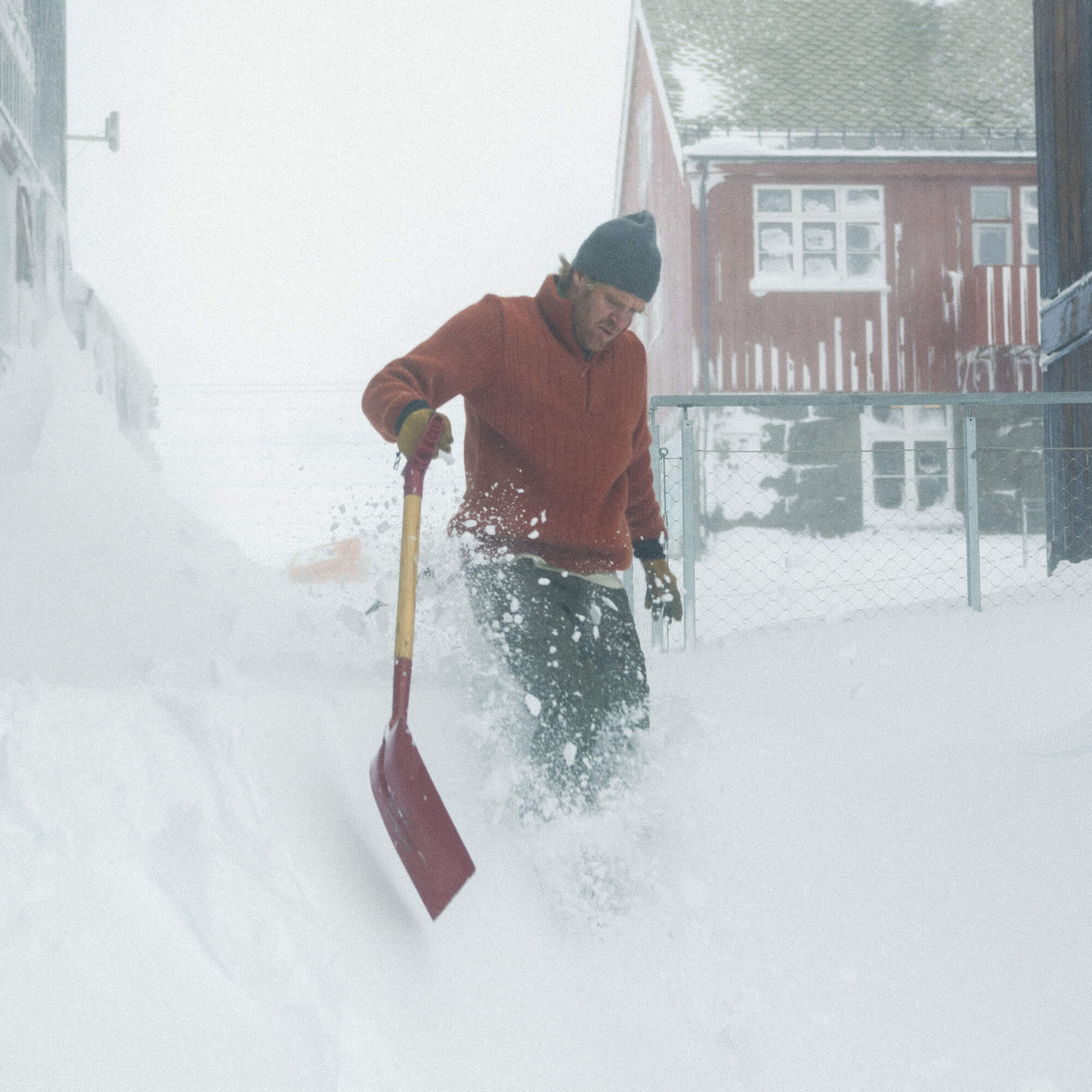 Mann på snøfjell med Janus Wool Finse genser i farge rød
