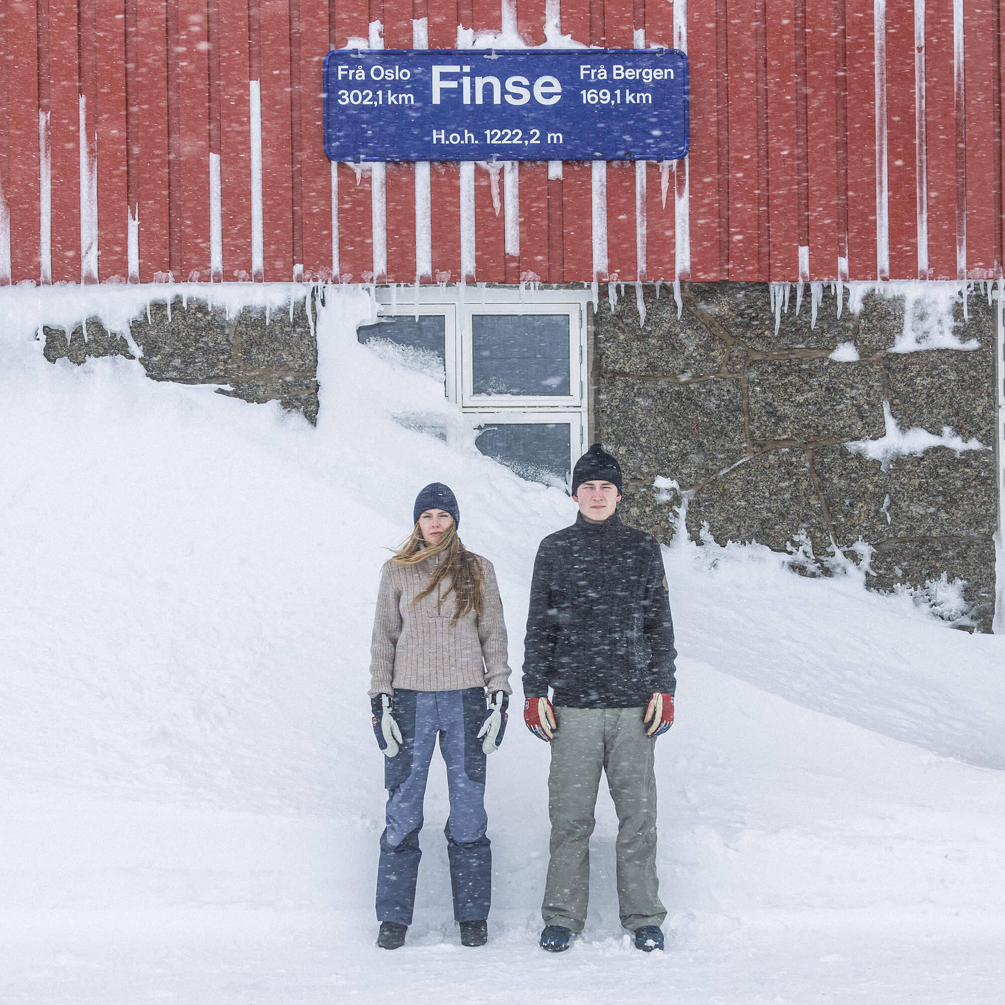 Jente og gutt på Finse stasjon med Janus Wool Finse gensere i farge beige og svart