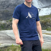 Person wearing a Janus merino blue t-shirt with a white graphic in a mountainous landscape