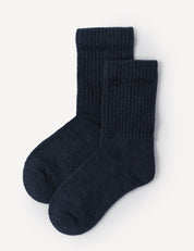A pair of Navy Terry Socks – Merino Kids, featuring a ribbed crew design and crafted from thick, cozy material, are neatly laid out on a white background.
