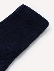Close-up of the Terry Socks – Merino Kids in dark navy blue on a plain white background, showcasing the ribbed texture and knit pattern characteristic of merino wool terry socks.