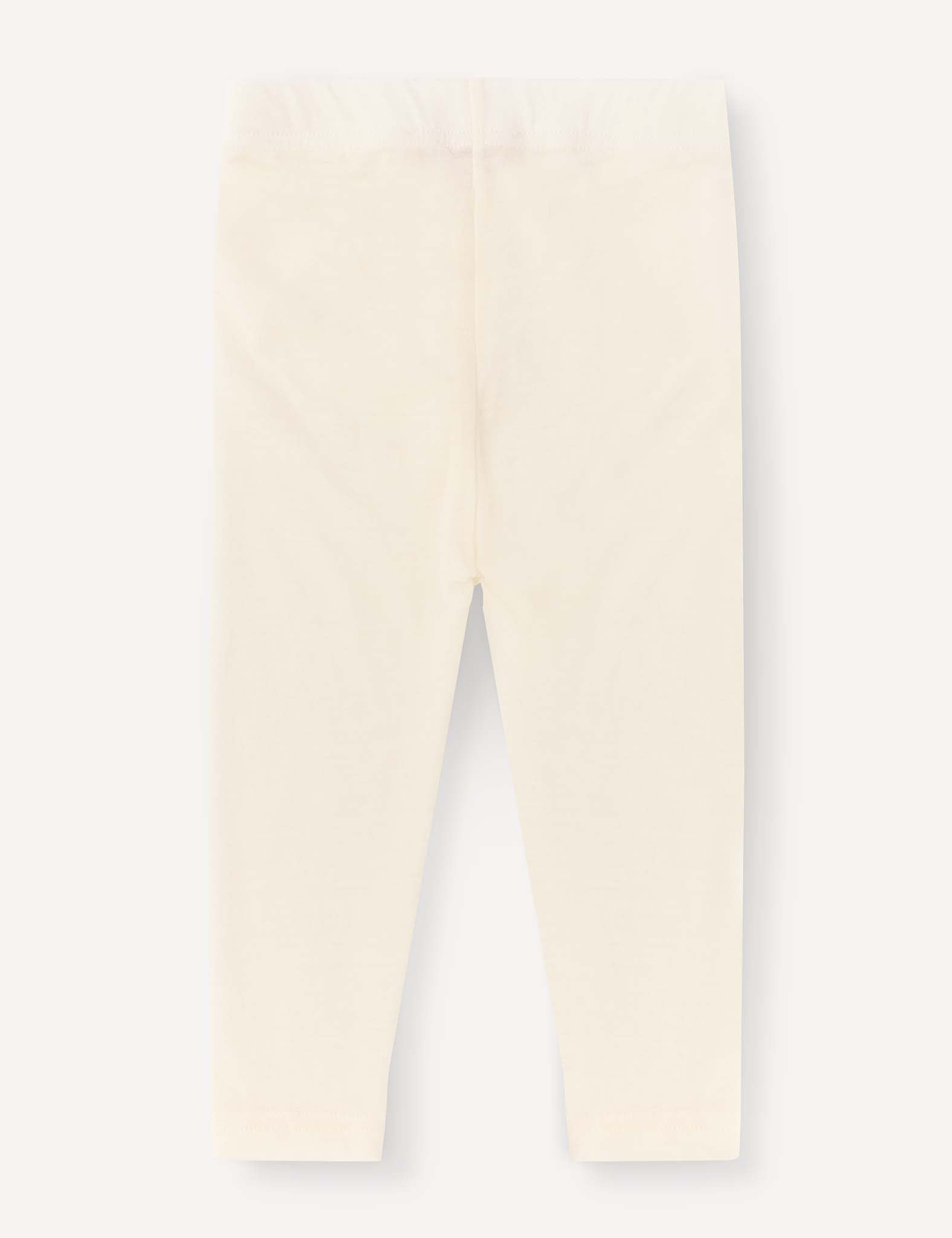 The Leggings – Merino Baby Light are cream-colored, full-length baby leggings shown flat on a light background, designed with an elastic waistband and no visible patterns or designs. These lightweight leggings provide a comfortable base layer for your little one.