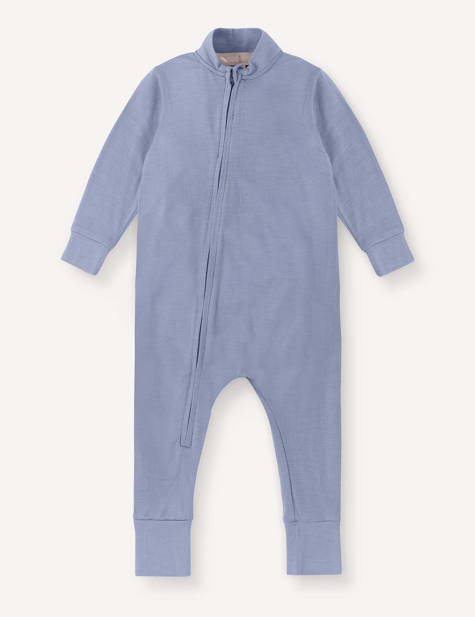 Troposphere-colored, long-sleeve Pyjamas – Merino Baby Light onesie featuring a diagonal zip closure from the neck to the left leg and ribbed cuffs on the sleeves and legs. Crafted in a breathable pyjama style, it is displayed against a plain background.
