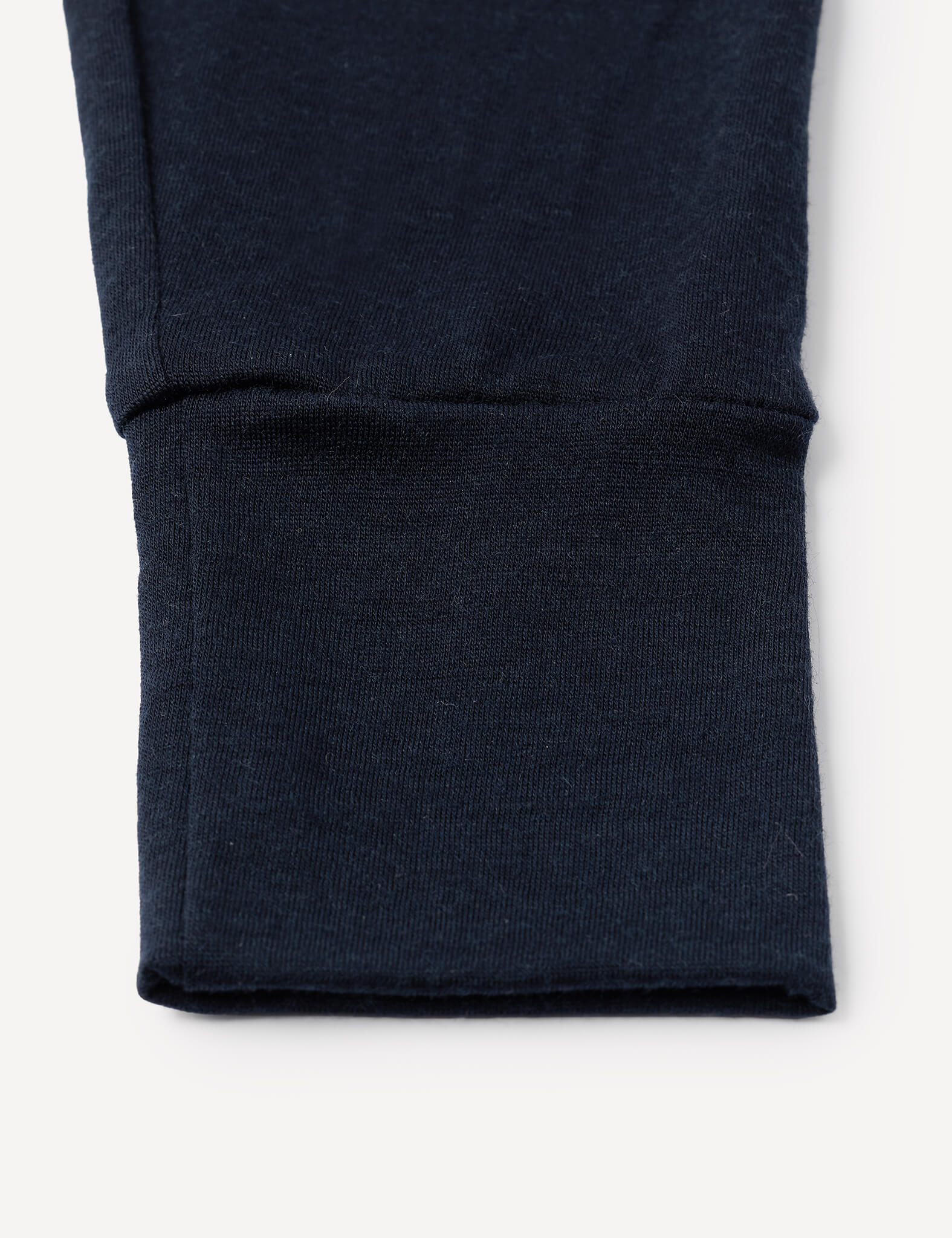 Close-up of a navy blue ribbed cuff on a sleeve, part of the Pyjamas – Merino Baby Light, against a white background.