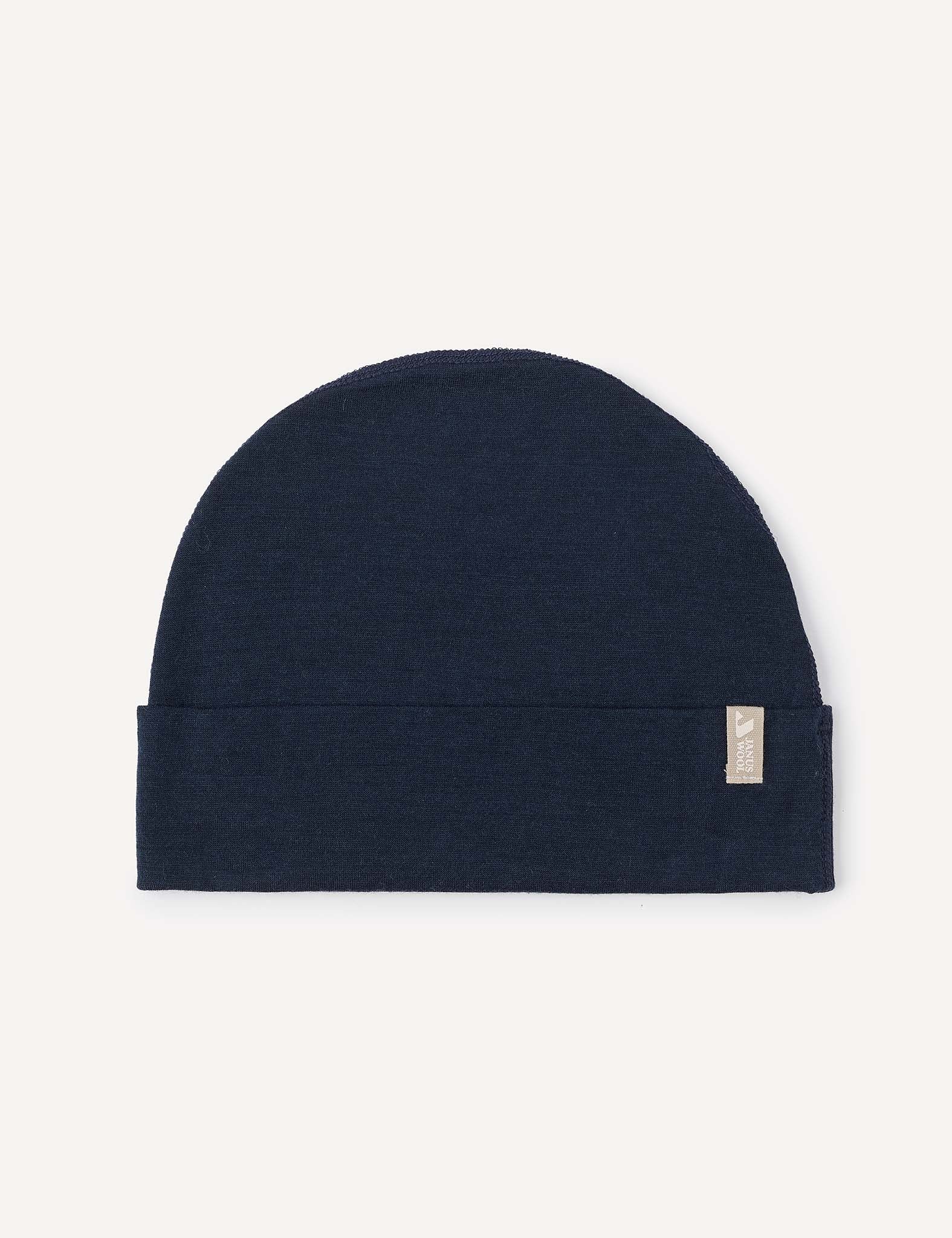 A lightweight Navy “Beanie – Merino Baby Light” with a subtle folded brim and a small beige fabric tag on the right side, displayed on a light background.