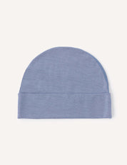 A light blue Beanie – Merino Baby Light, crafted from ultra-soft merino wool, is laid flat on a plain white background. This lightweight baby beanie features a simple, seamless design and a folded brim at the bottom, offering breathable comfort for everyday wear.