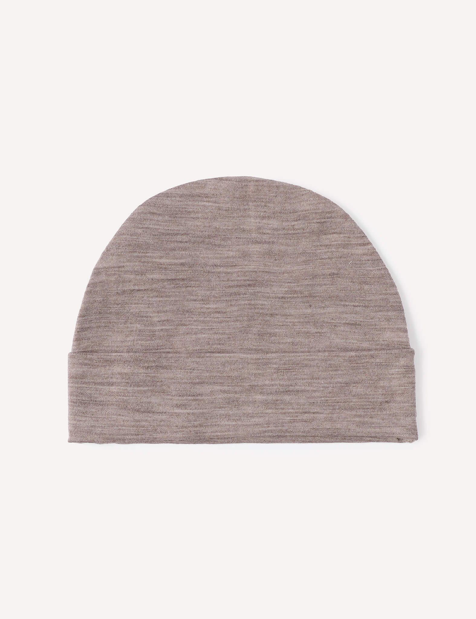 The Beanie – Merino Baby Light is shown on a white background, highlighting its simple, minimalist design with a slightly curved top in a plain light brown knit. Made from lightweight merino material, this beanie provides comfort and style for your baby.