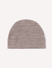 The Beanie – Merino Baby Light is shown on a white background, highlighting its simple, minimalist design with a slightly curved top in a plain light brown knit. Made from lightweight merino material, this beanie provides comfort and style for your baby.