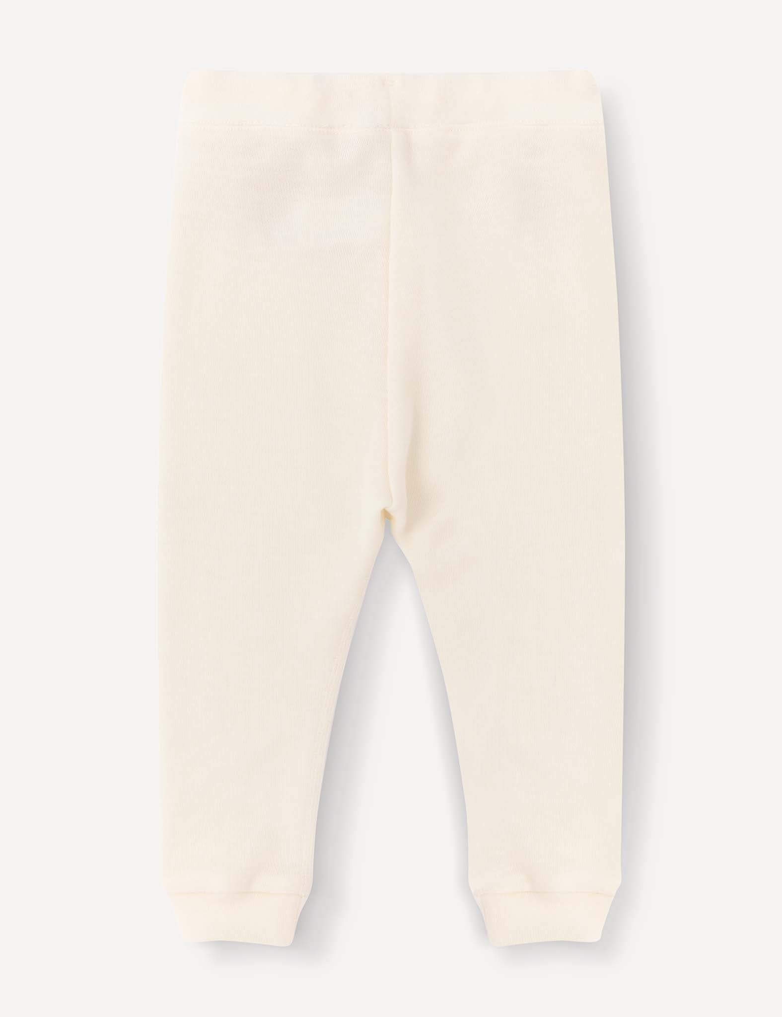 Cream-colored Merino Baby AirWool pants for babies or toddlers, featuring an elastic waistband and cuffed ankles, laid flat on a light background and displayed from the back for a relaxed fit.