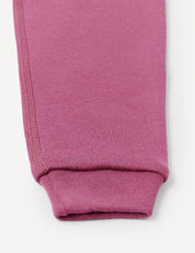 Close-up of the cuff of a pink or mauve knit sleeve, highlighting the seam and ribbed texture against a white background, paired with relaxed fit Pants – Merino Baby AirWool for a comfortable and stylish look.