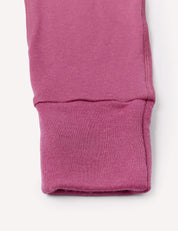 Close-up of a pink ribbed fabric cuff, likely from the sleeve of the Onesie – Merino Baby AirWool, featuring fold-over cuffs and displayed on a white background.