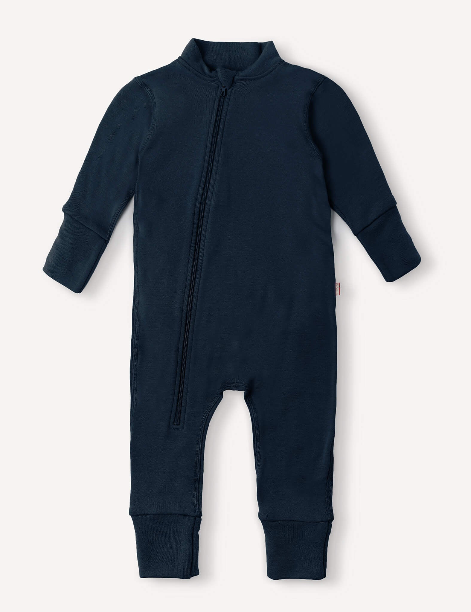 Introducing the Onesie – Merino Baby AirWool in navy, a long-sleeved, full-length suit crafted from breathable merino wool for optimal insulation. Featuring a diagonal front zipper from neck to leg and fold-over cuffs for extra comfort.