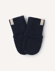 A pair of navy Merino Baby AirWool mittens featuring warm knit material, folded cuffs, and beige fabric tags attached to the top edges, displayed against a light background.