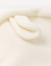 Close-up of a soft, cream-colored knitted fabric with a small, folded loop detail near the top, highlighting the breathable Balaclava – Merino Baby AirWool winter headwear.