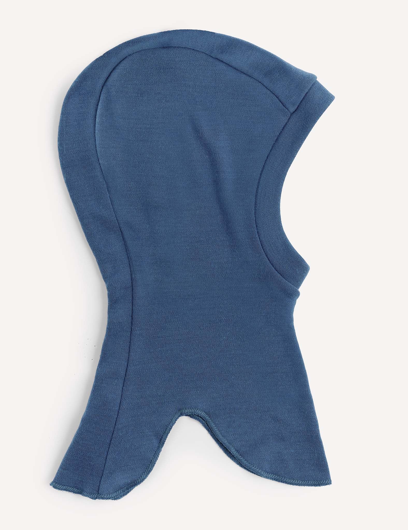 An Ensign Blue Balaclava – Merino Kids AirWool, featuring a hood-shaped design made from soft fabric, is shown laid flat on a light surface with a rounded top and flared, pointed bottom edges.