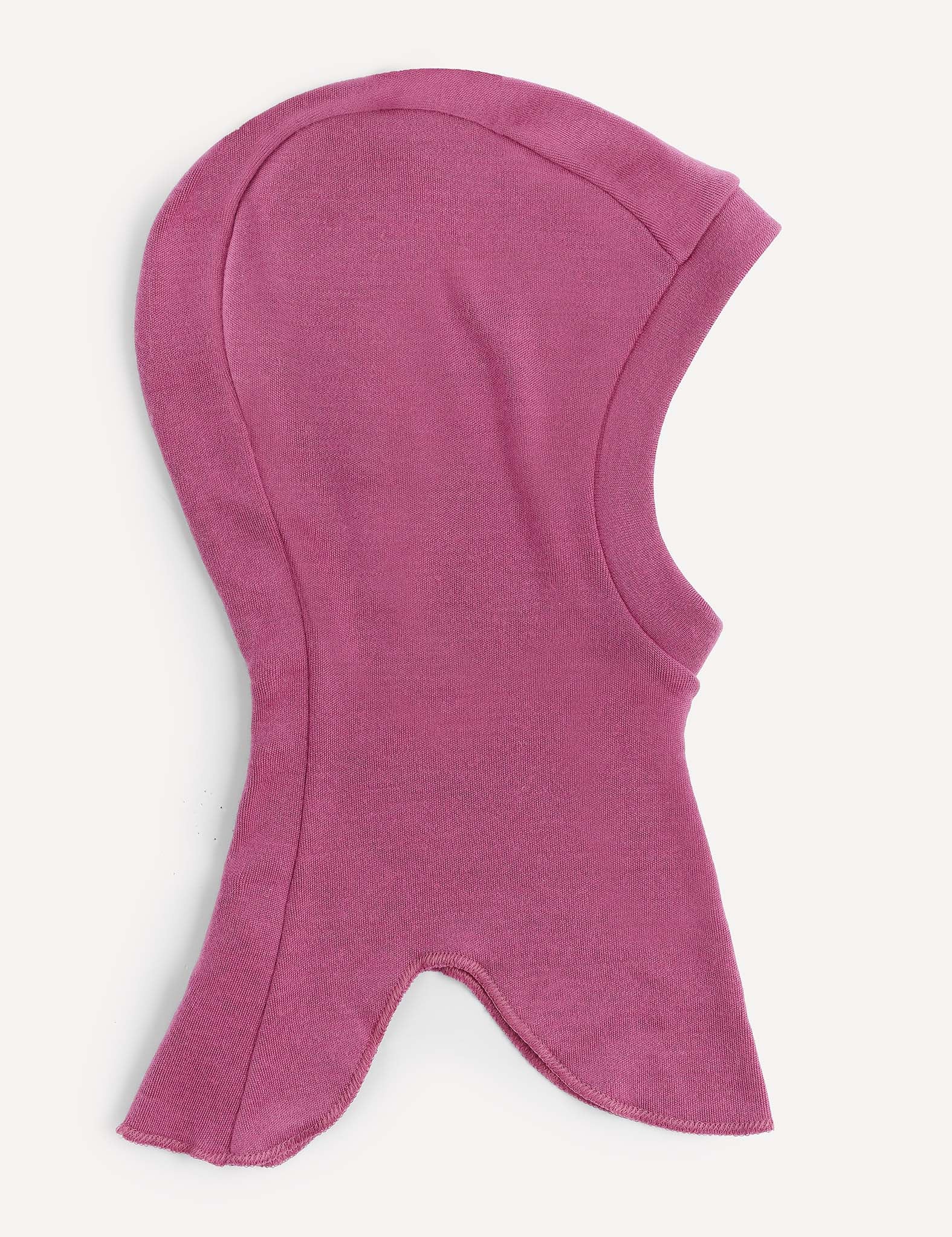 The Balaclava – Merino Kids AirWool, crafted from soft pink merino wool, is shown laid flat on a light background. It features a face opening and a flared bottom edge.