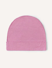 The Beanie – Merino Kids Light in a soft, light pink wool is laid flat on a white background.