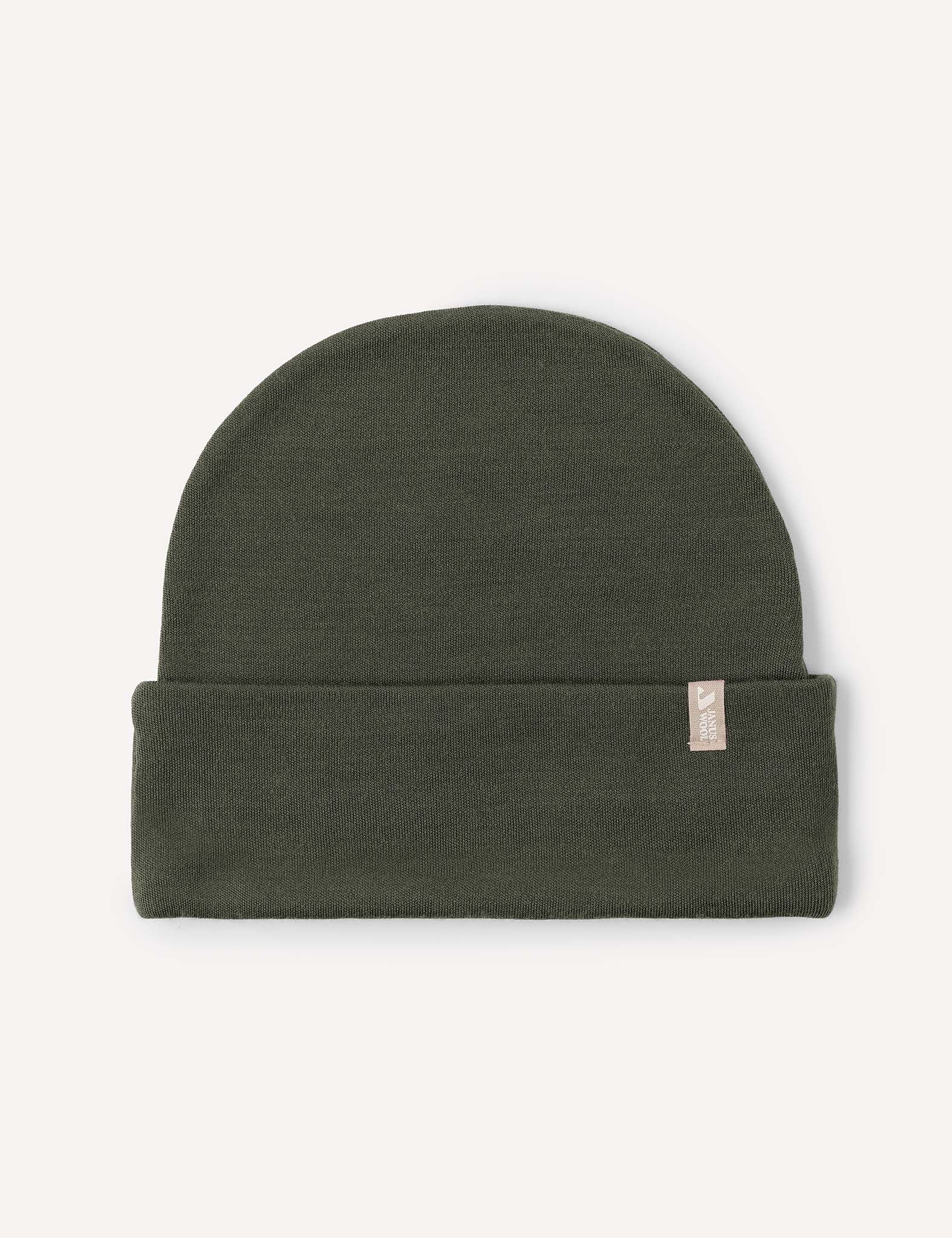 A folded Forest Night Beanie – Merino Kids AirWool, featuring a small beige tag on the cuff, is displayed on a plain light background. This breathable merino wool hat is designed to keep you extra warm.