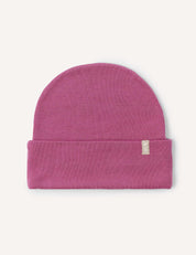 The Beanie – Merino Kids AirWool is a pink merino wool hat featuring a folded brim and a small rectangular fabric tag, shown against a plain white background. Extra warm and breathable, it’s perfect for keeping kids cozy on chilly days.