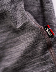 Close-up of the T-shirt Active – Classic Merino 160 Women in gray, showing visible stitching and a MERINO WOOL tag near the seam, highlighting its temperature-regulating properties.