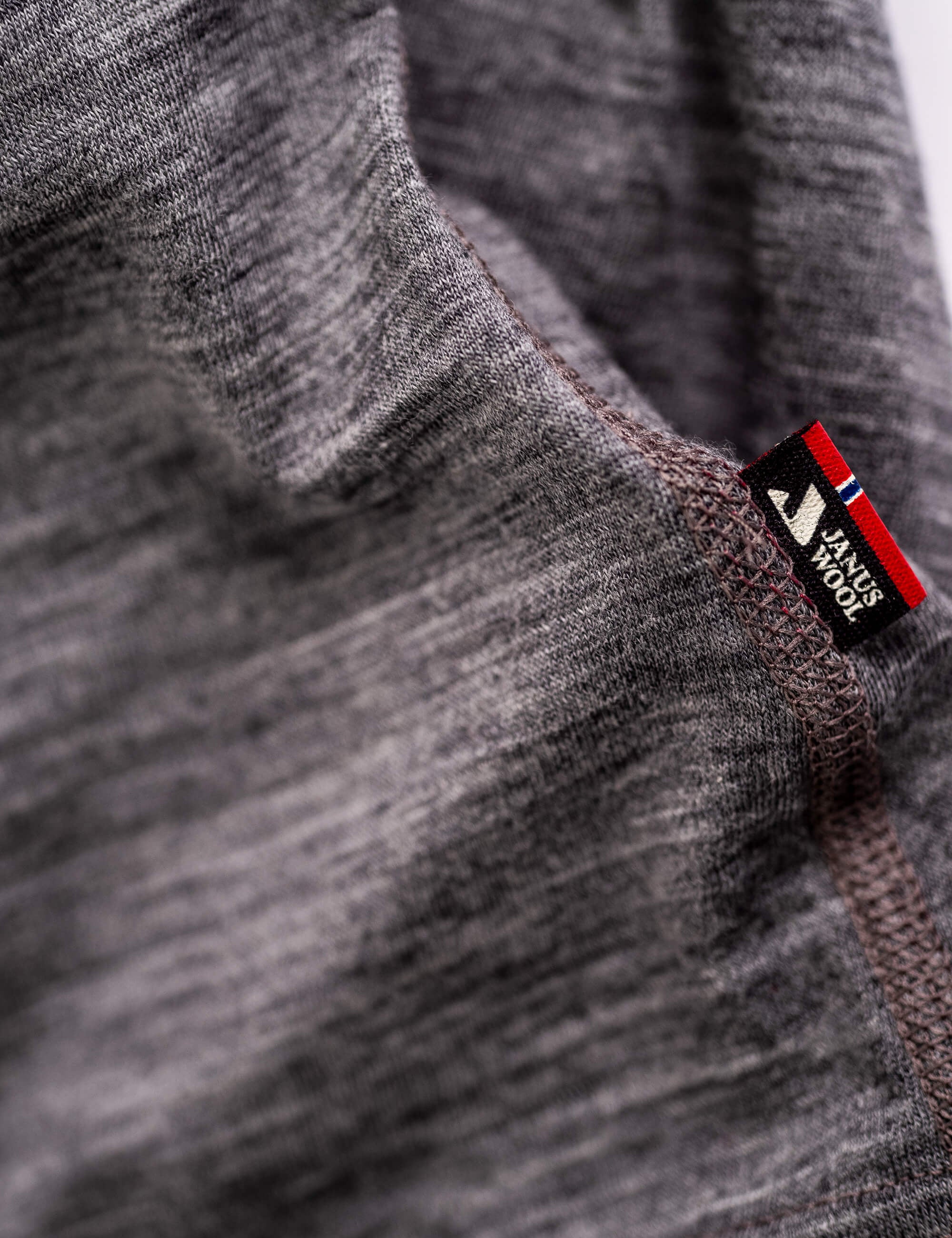 Close-up of the T-shirt Active – Classic Merino 160 Women in gray, showing visible stitching and a MERINO WOOL tag near the seam, highlighting its temperature-regulating properties.