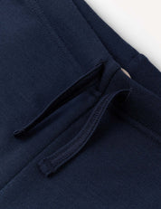 Close-up of the Flarepants – Merino Kids AirWool in navy blue, made from AirWool 260 merino wool, showcasing a pocket with a drawstring detail and visible stitching against a plain light background.