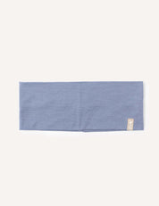 A folded, rectangular Troposphere-colored merino wool headband (Headband – Merino Kids Light) with a small beige fabric tag sewn on one corner, displayed on a plain white background.