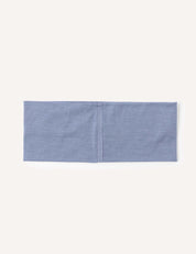 A folded, rectangular piece of light blue fabric with a visible vertical seam in the center, laid flat on a plain white background—this is the Headband – Merino Kids Light, a versatile accessory designed for everyday use.