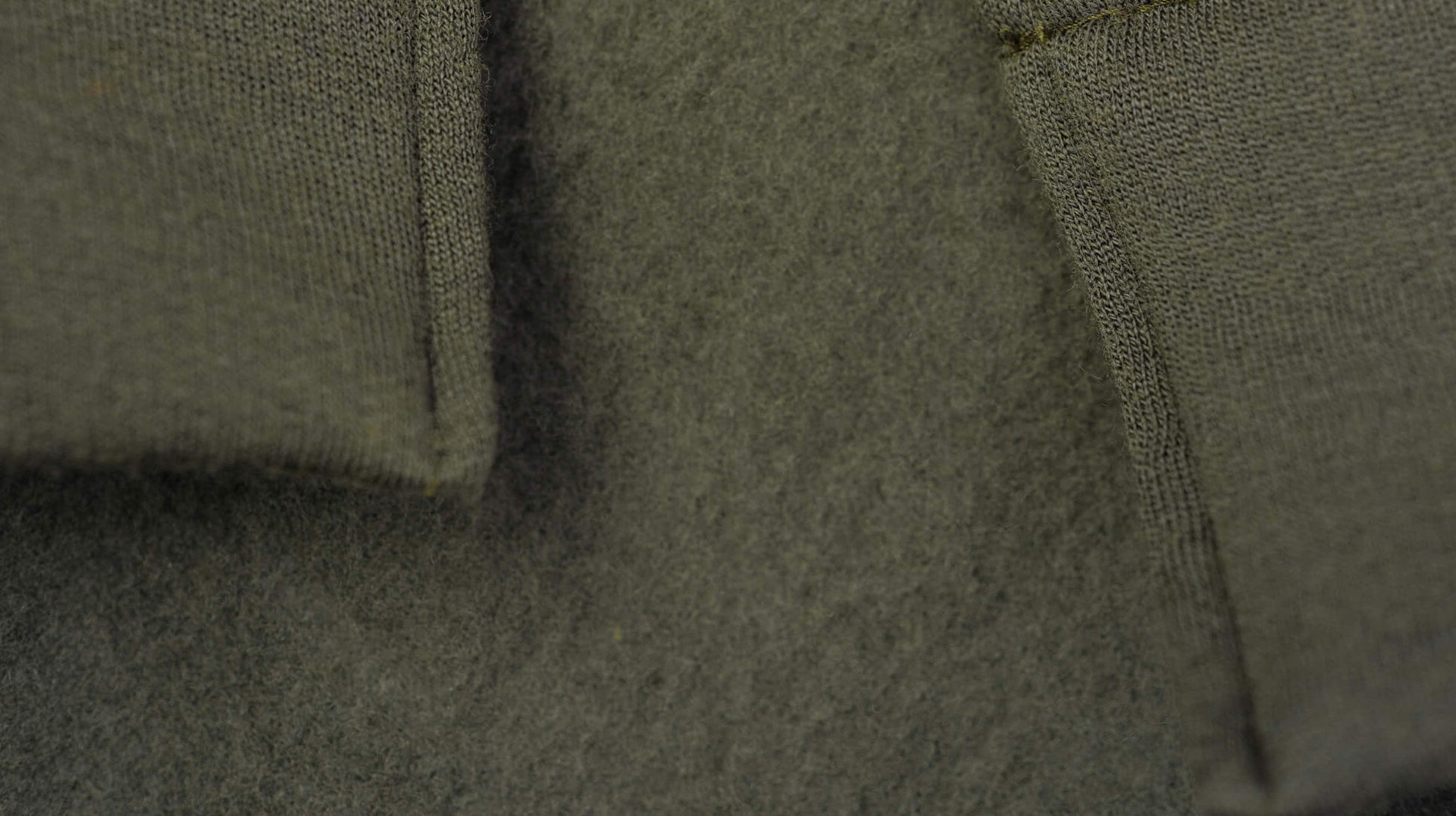Close-up of a textured green fabric with stitching details