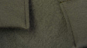 Close-up of a textured green fabric with stitching details