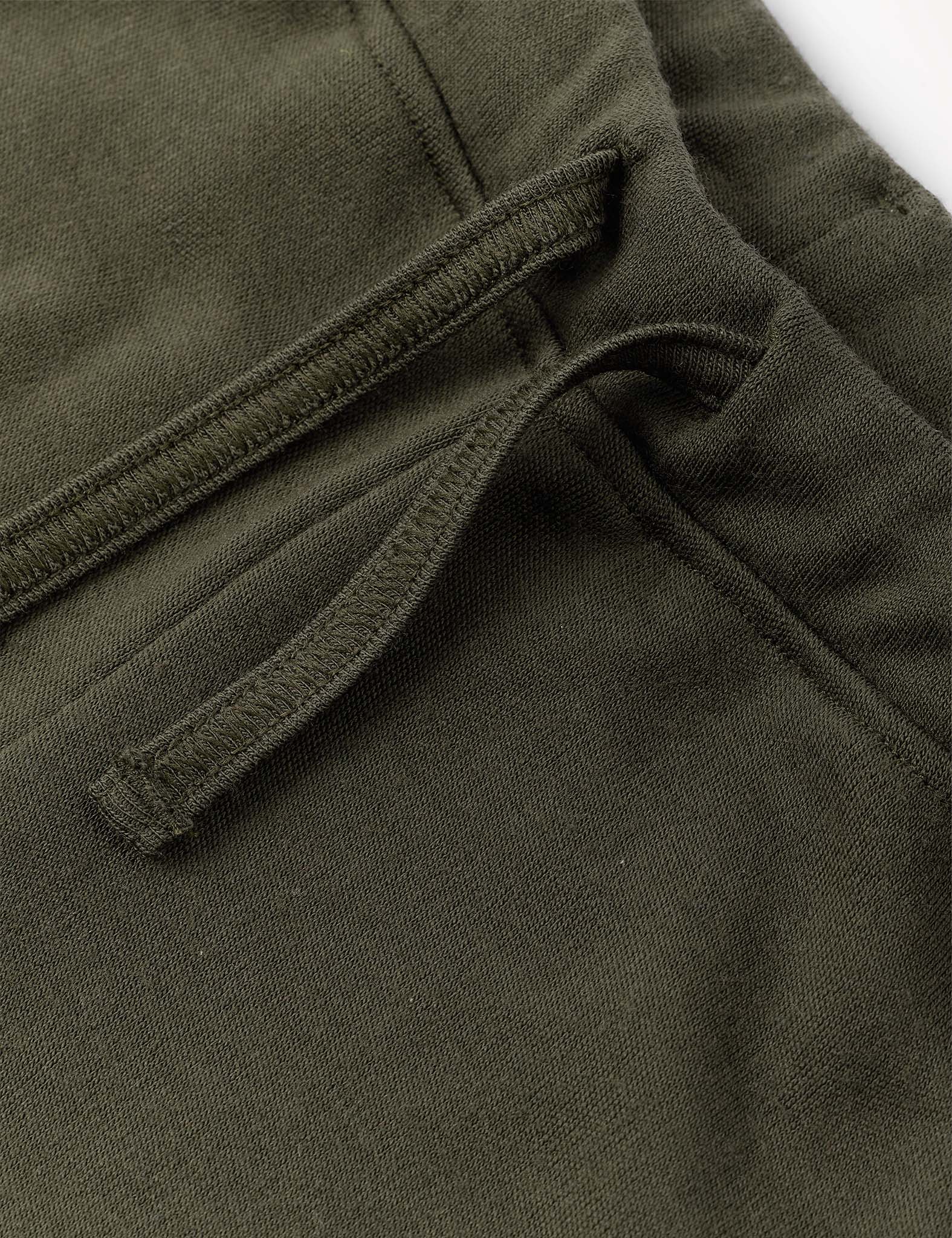 Close-up of the Sweatpants – Merino Kids AirWool in olive green, highlighting the drawstring and pocket detail, visible stitching, and soft merino wool fabric texture.
