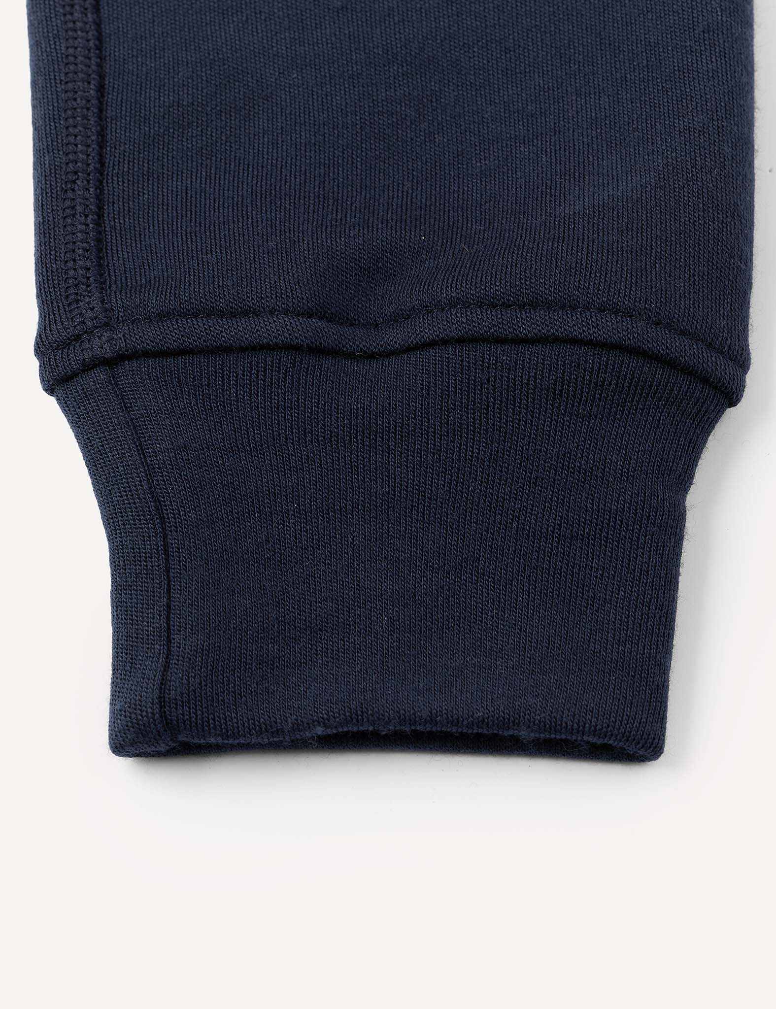 Close-up of the cuff of a navy blue sleeve from the Merino Kids AirWool Sweatpants, highlighting the ribbed fabric and detailed stitching.