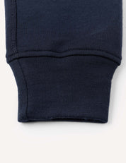 Close-up of the cuff of a navy blue sleeve from the Merino Kids AirWool Sweatpants, highlighting the ribbed fabric and detailed stitching.