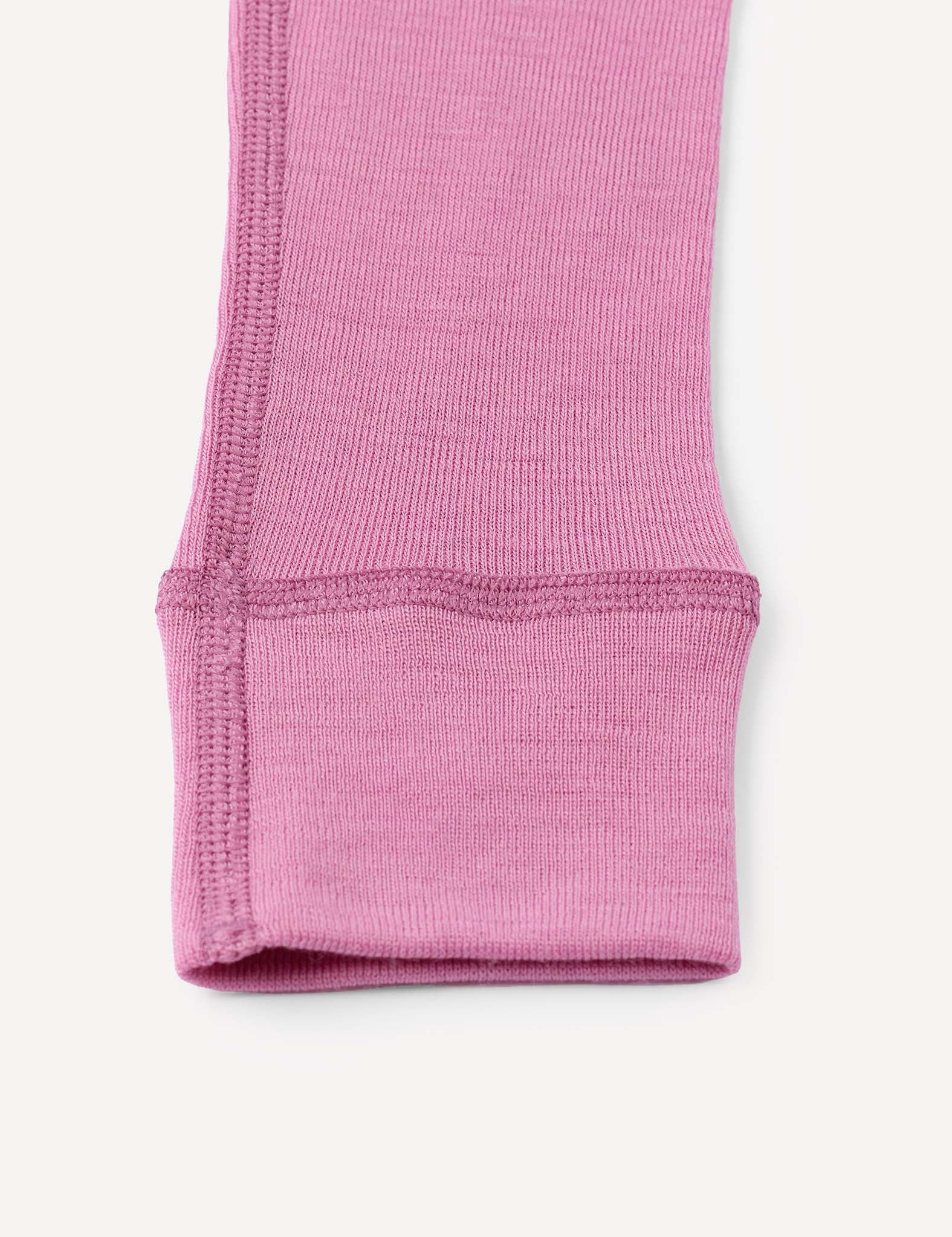 Close-up of the cuff of the Merino Kids Classic Rib Leggings in pink, highlighting the detailed ribbed texture and fine stitching against a white background.