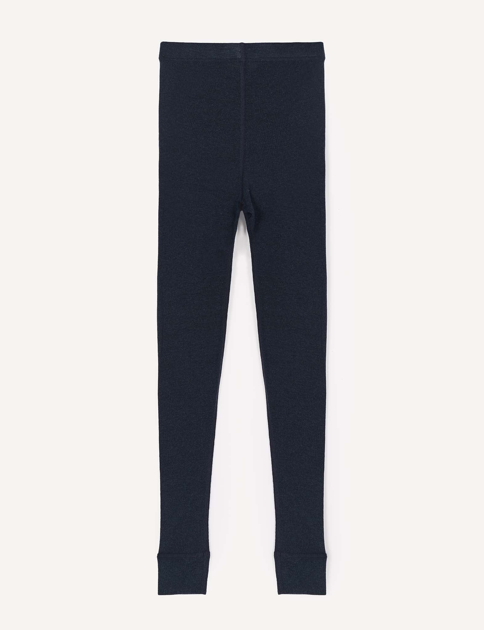 A pair of Leggings – Merino Kids Classic Rib in plain, dark navy blue merino wool is laid flat on a white background, showcasing visible seams, ankle cuffs, and an elastic waistband.