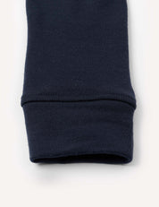 Close-up of the cuff of a navy blue Leggings – Merino Kids AirWool, made of warm brushed AirWool ribbed fabric, laying flat on a white background.