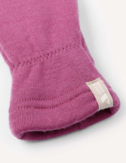 A close-up of a purple knitted sleeve from the Mittens – Merino Kids AirWool, with a beige tag at the end featuring a white logo and text. The sleeve is neatly folded, highlighting the texture of the fabric.