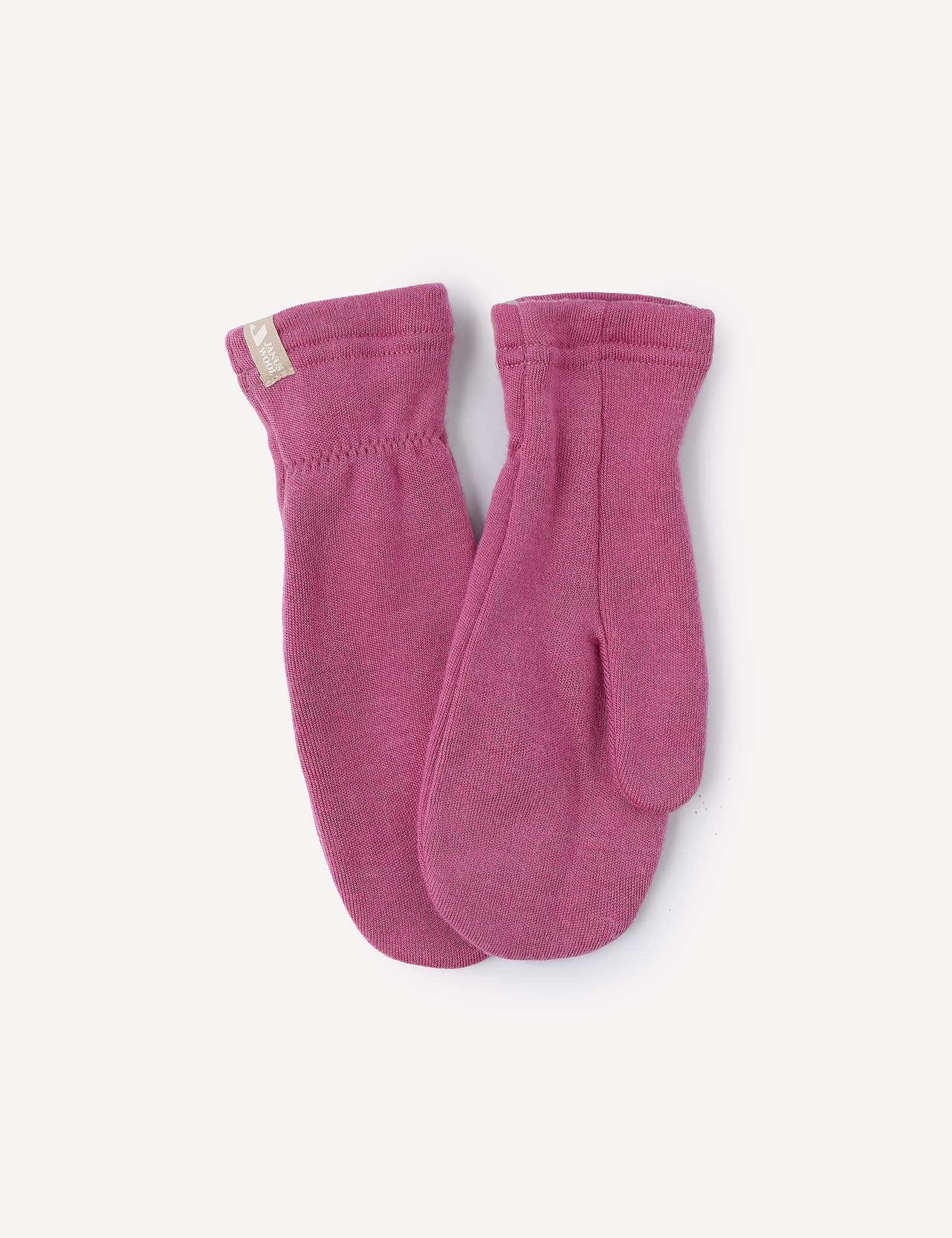 A pair of Mittens – Merino Kids AirWool in pink is laid flat on a light background, with one mitten slightly overlapping the other. A small beige tag is sewn onto the cuff of one mitten.