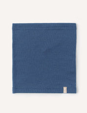 A flat, square-shaped blue Neckwarmer – Merino Kids AirWool made of wool, featuring a small beige tag on the bottom right corner, displayed against a plain white background.