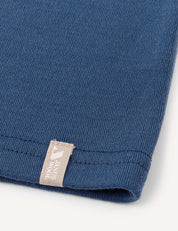 Close-up of a blue knitted fabric, likely the Neckwarmer – Merino Kids AirWool, featuring a small beige tag.