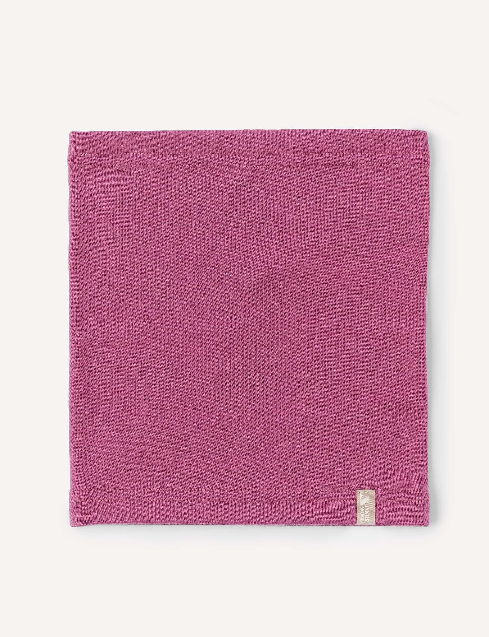 A rectangular piece of pink fabric with finished edges lays flat on a white background, featuring a small beige tag attached near the bottom edge. The Neckwarmer – Merino Kids AirWool offers a stylish and comfortable accessory, perfect for everyday wear.