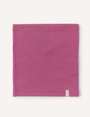 A rectangular piece of pink fabric with finished edges lays flat on a white background, featuring a small beige tag attached near the bottom edge. The Neckwarmer – Merino Kids AirWool offers a stylish and comfortable accessory, perfect for everyday wear.